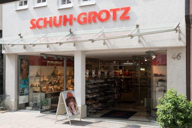 Storefront of a shoe shop named SCHUH-GROTZ with prominent red lettering and display windows.
